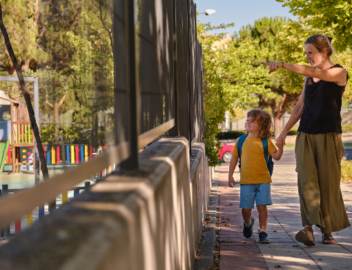 Mãe e filho andando frente a escola